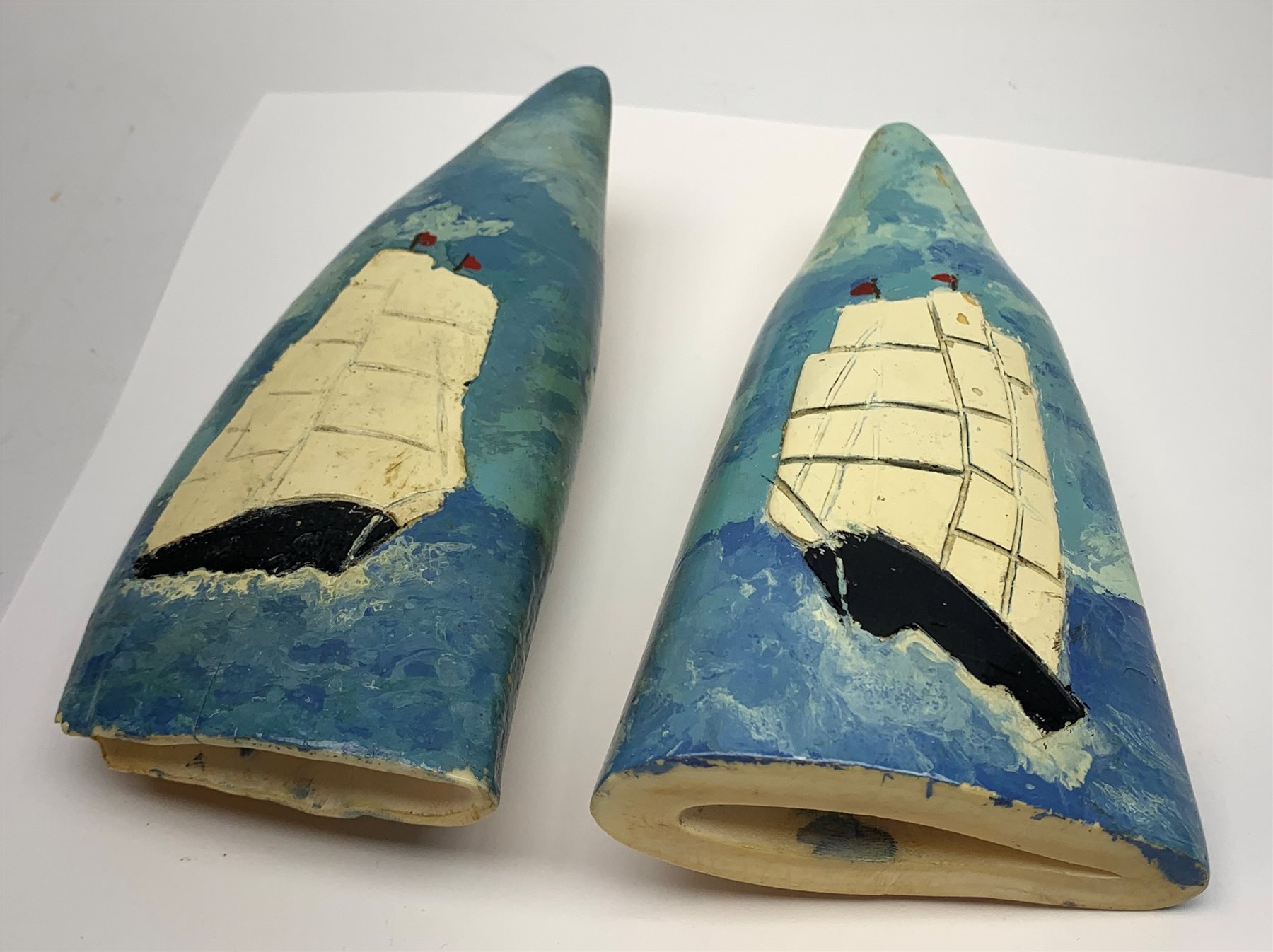 Pair of sperm whale teeth, relief decorated and painted with three-masted whaling ships H14.5cm (2)