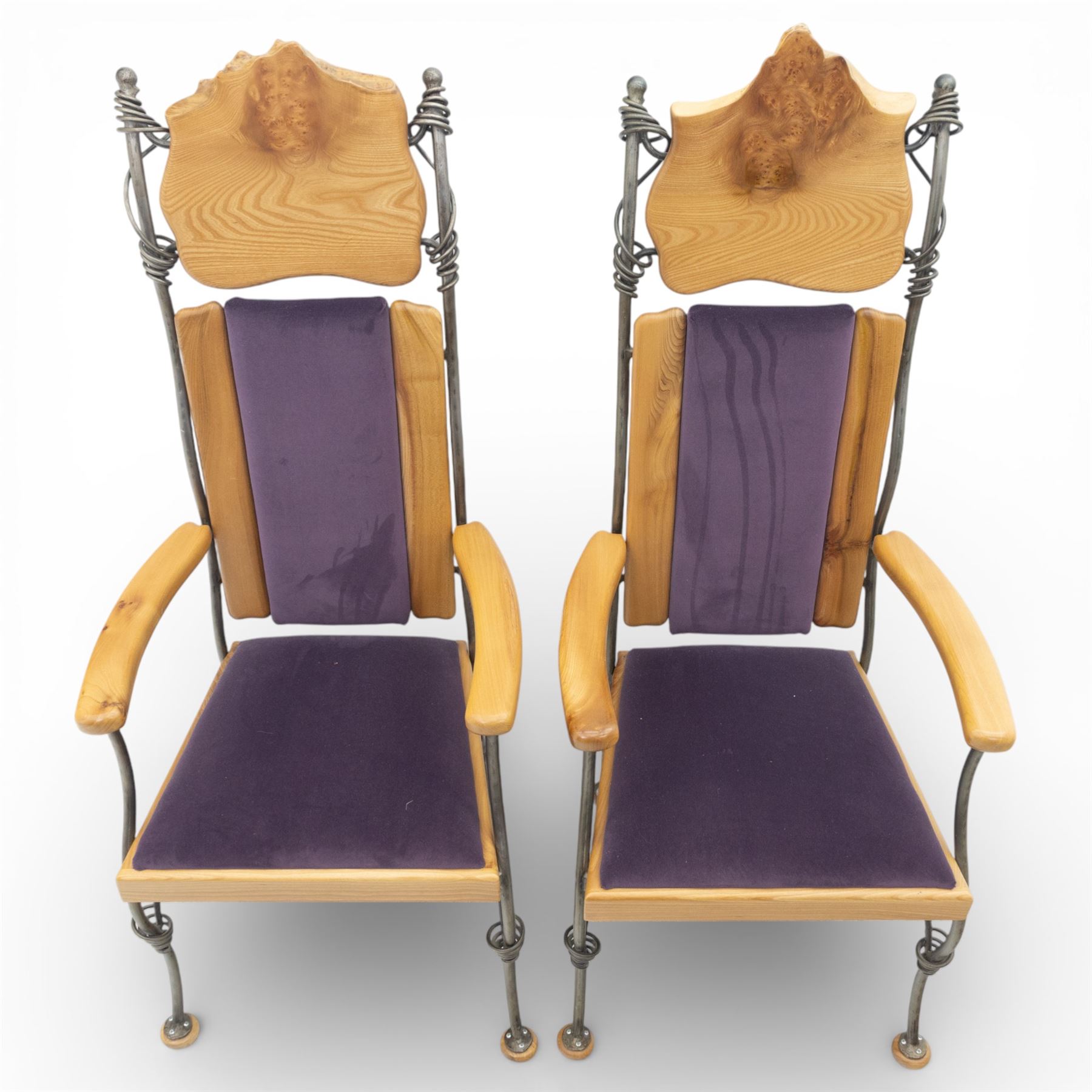 Paul Hodgkiss Designs of Glasgow - contemporary shaped elm dining table with wrought iron base; with set ten (8+2) matching high-back dining chairs, table of organic form above an elaborate wrought iron supports, with central elm stretcher, the chairs with en suite with matching wrought iron work burred elm headrest, purple velour upholstery with drop in seat     

Table: W 102cm, L 243cm, H 74cm
Chairs: W 56cm, D 52cm, H 130cm