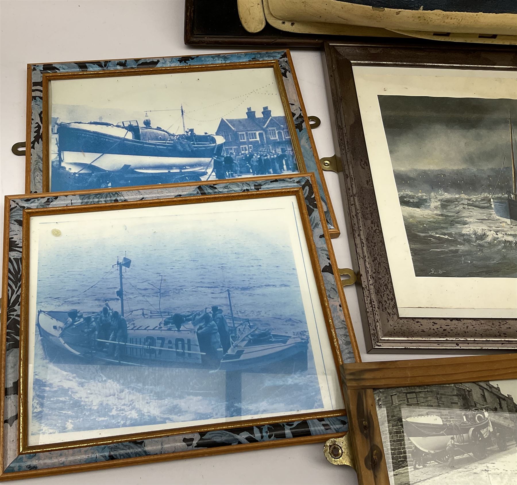 RNLI collection box in the form of a boat makers half block model, painted in the colours of a lifeboat with flag and ship motifs, H25cm, L73cm together with framed photos, postcards and prints of lifeboats and crew, including Scarborough lifeboat station