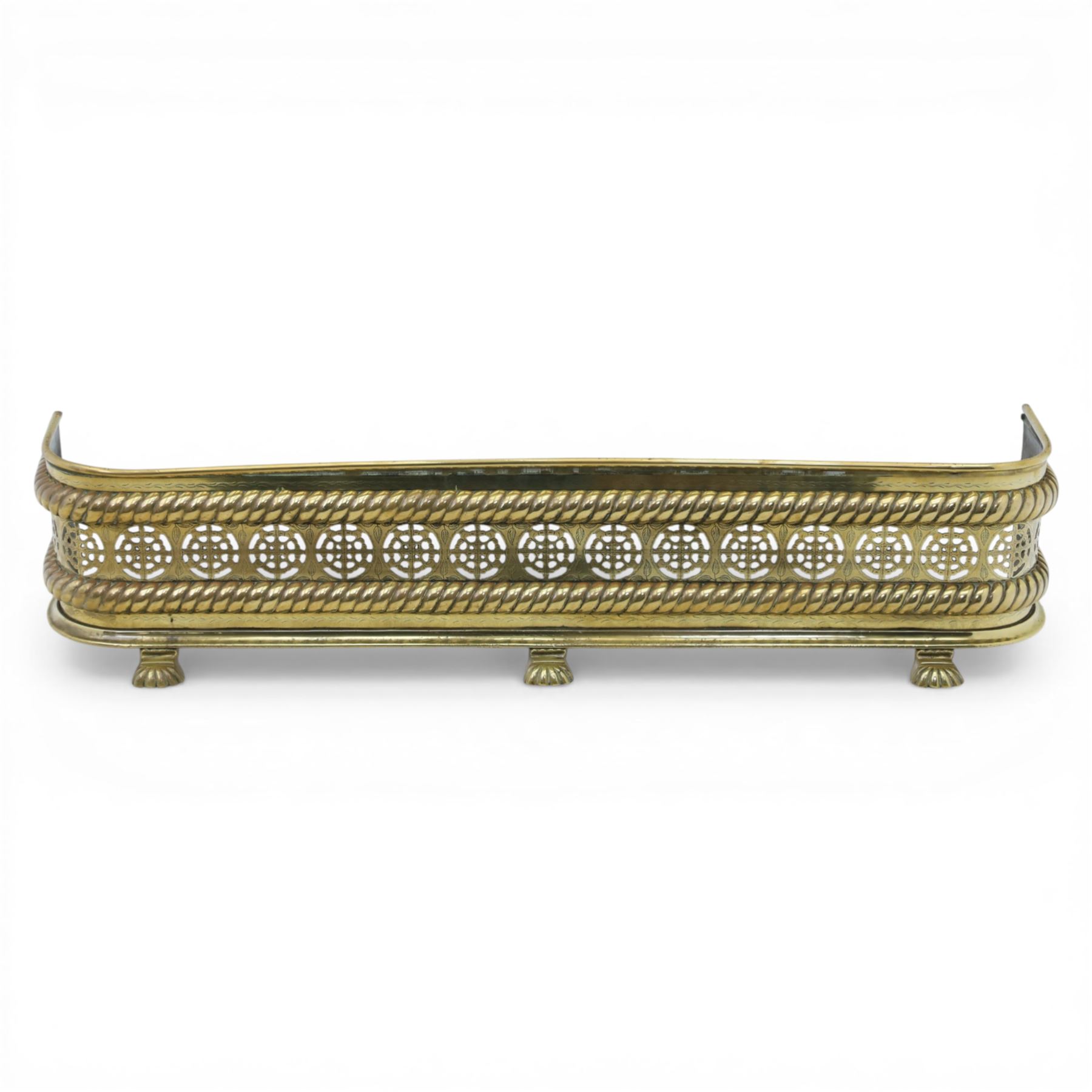 20th century pierced brass fender, with pierced roundels between oblique gadrooned borders, upon three paw feet