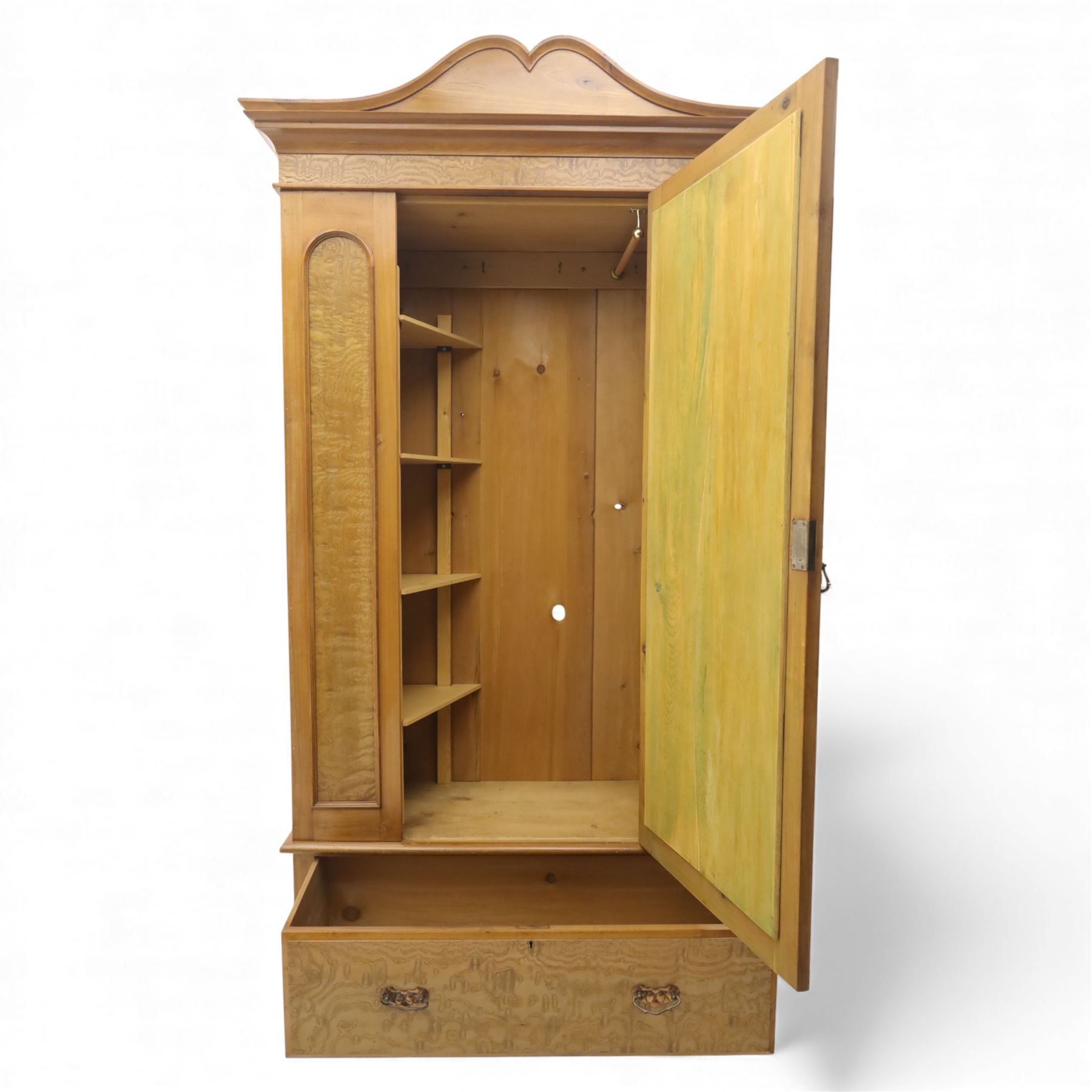 Victorian satin walnut single door wardrobe, shaped cavetto cornice above a central arched mirrored door flanked by recessed panelled sides, the interior fitted with hanging space and later added corner shelves, over a single long drawer with brass handles, on a plinth base