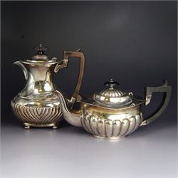 Late Victorian silver hot water pot, of oval part fluted form with ebonised wooden handle ...