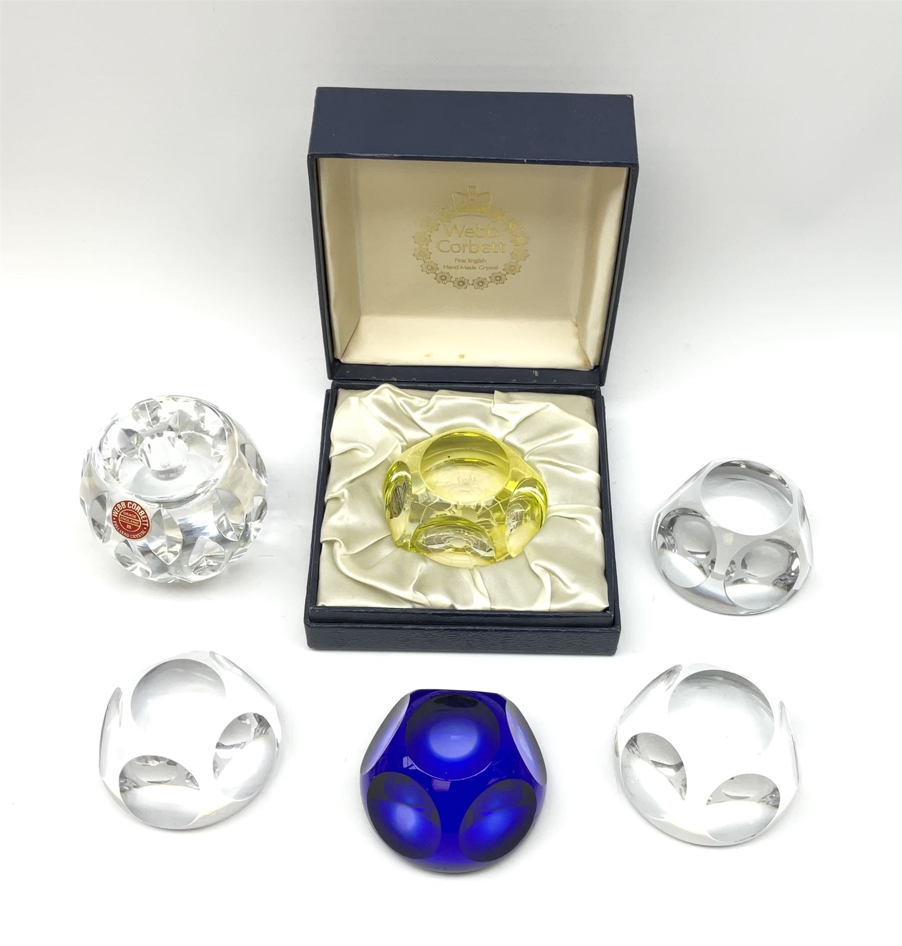 A group of six Webb Corbett faceted glass paperweights, to include one blue example, and one yellow example in makers box. 