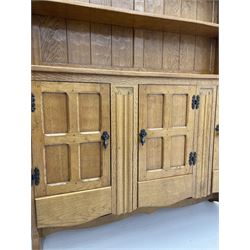‘Gnomeman’ adzed oak dresser, raised two heights plate rack over rectangular top, three cupboards enclosed by panelled doors each above drawer, carved linen fold uprights, shaped end supports joined by shaped pegged stretcher, carved with gnome signature, by Thomas Whittaker of Littlebeck