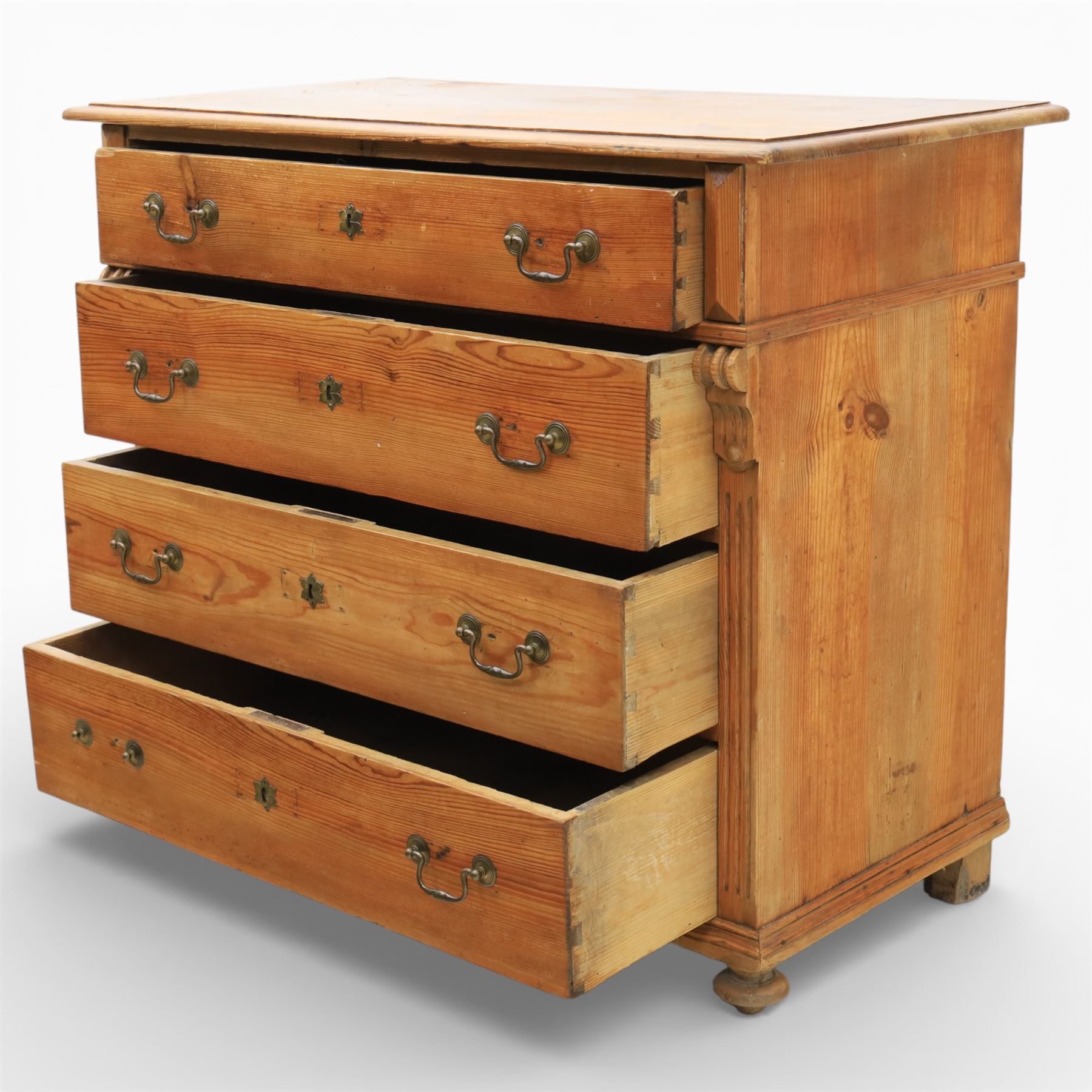 Late Victorian pine chest of drawers, the moulded top above four long drawers with brass drop handles and flower head escutcheons, flanked by pilasters, upon four turned compressed bun feet, 89cm x 103cm x 54cm
