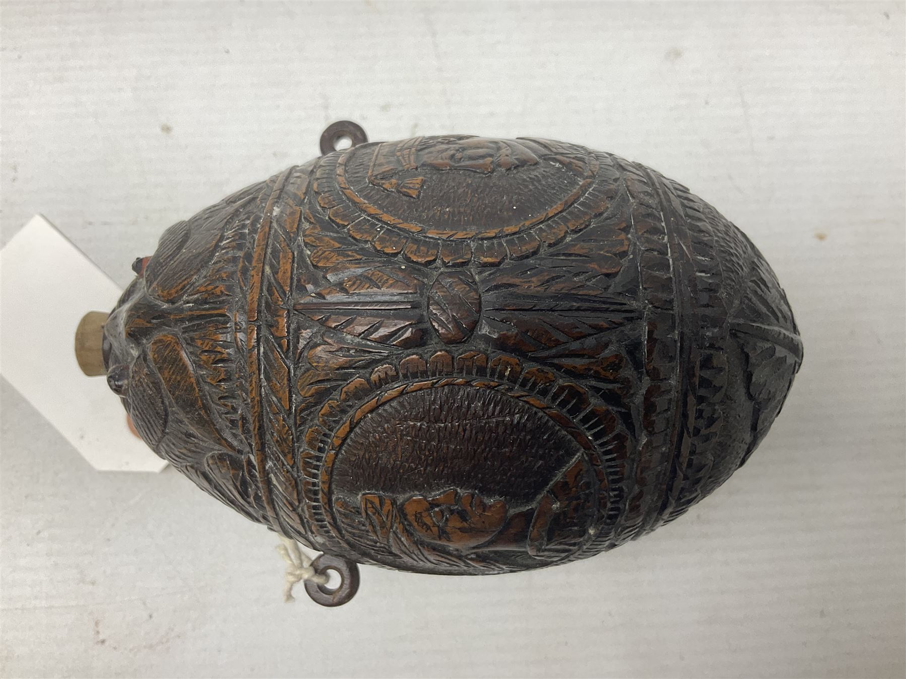 19th century bug bear flask carved with Balkan figures, a wolf and leafage with glass eyes, L14cm on stand 