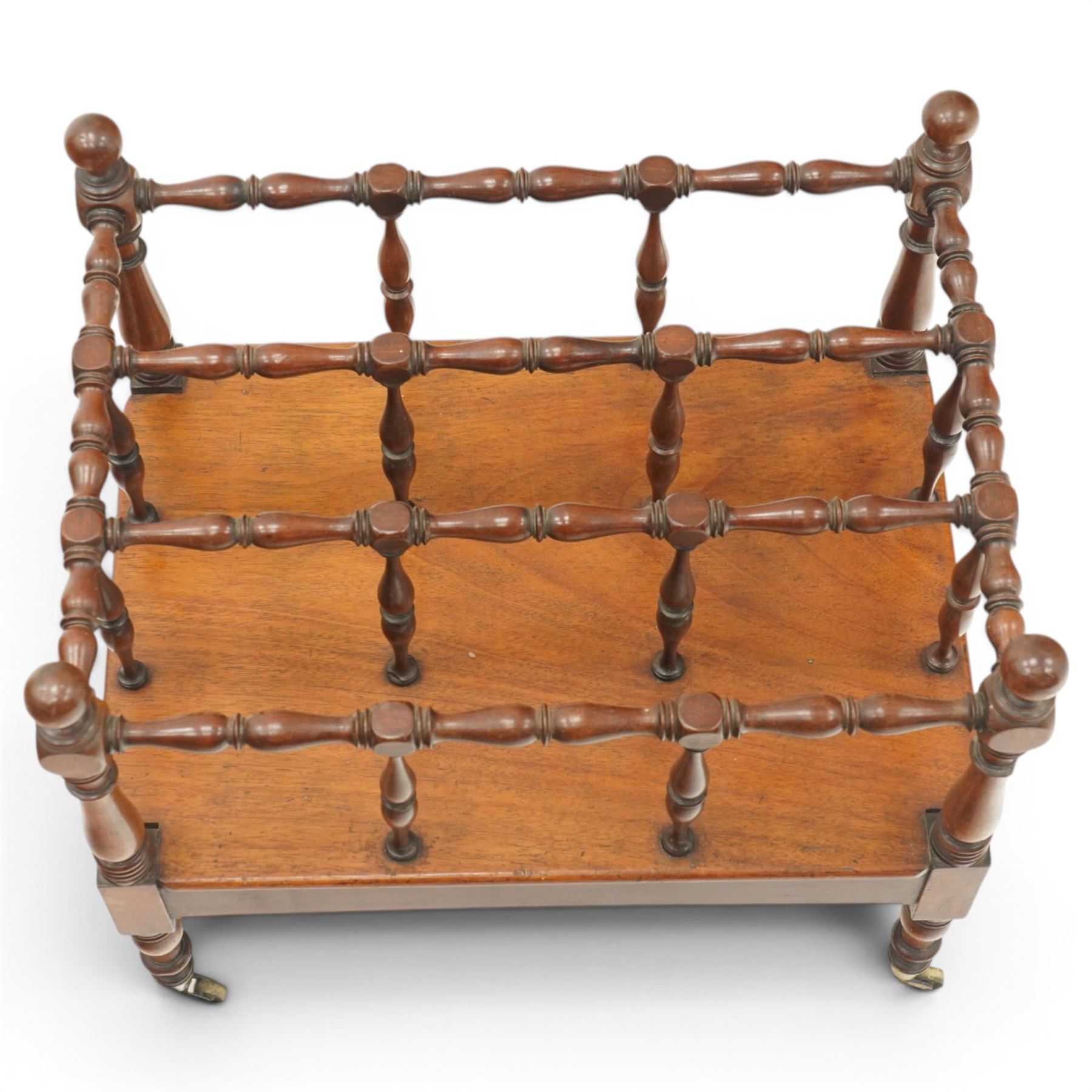 Victorian mahogany canterbury, four division top with bobbin turned rails and spindle uprights, rectangular base with moulded edge, on turned corner supports with brass castors