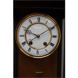  Late 19th century walnut and ebonised Vienna wall clock with broken arched pediment over a single glazed door, the brass and enamel dial with Roman numerals and eight day movement striking on a gong, on ogee base H77cm  