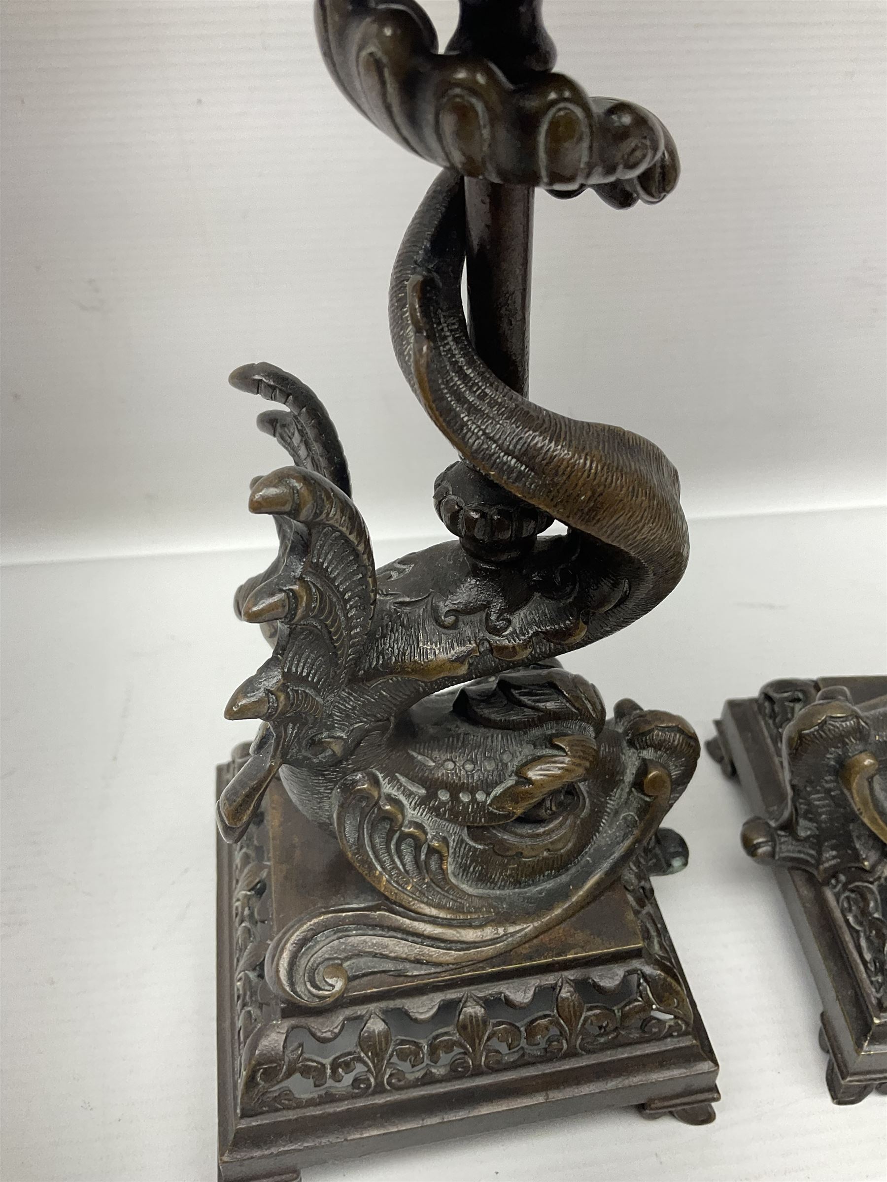 Pair of late 19th/ early 20th century brass candlesticks in the form of dolphins upon a stepped base with Fleur-de-lis design, H32cm 