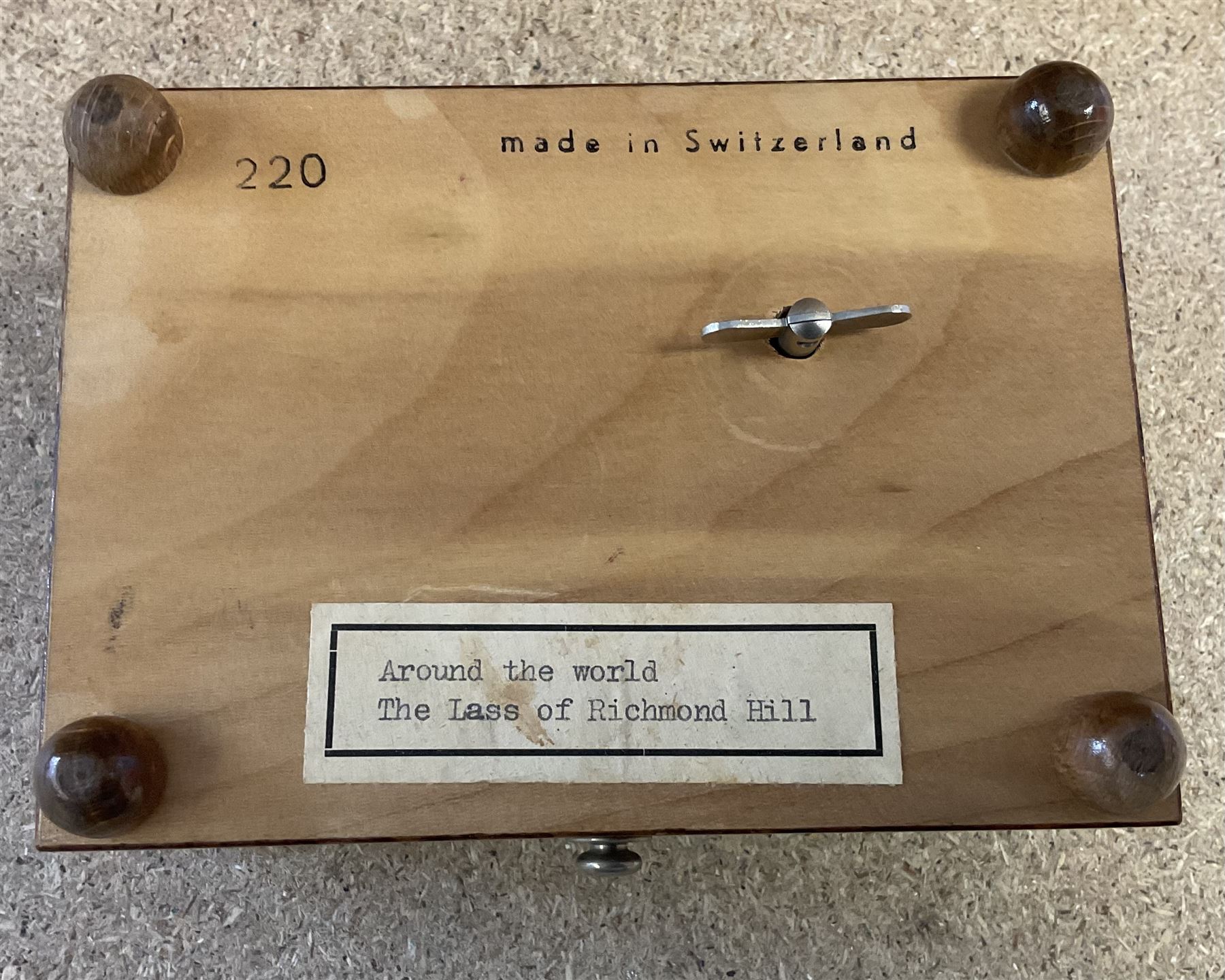 20th century burr wood Swiss musical box, marbled beneath 'made in Switzerland', paper label inscribed 'Around the world The Lass of Richmond Hill', H6.5cm W12.5cm D9cm