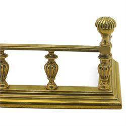 Edwardian brass fire kerb, with reeded and stepped base supporting baluster uprights and reeded top 