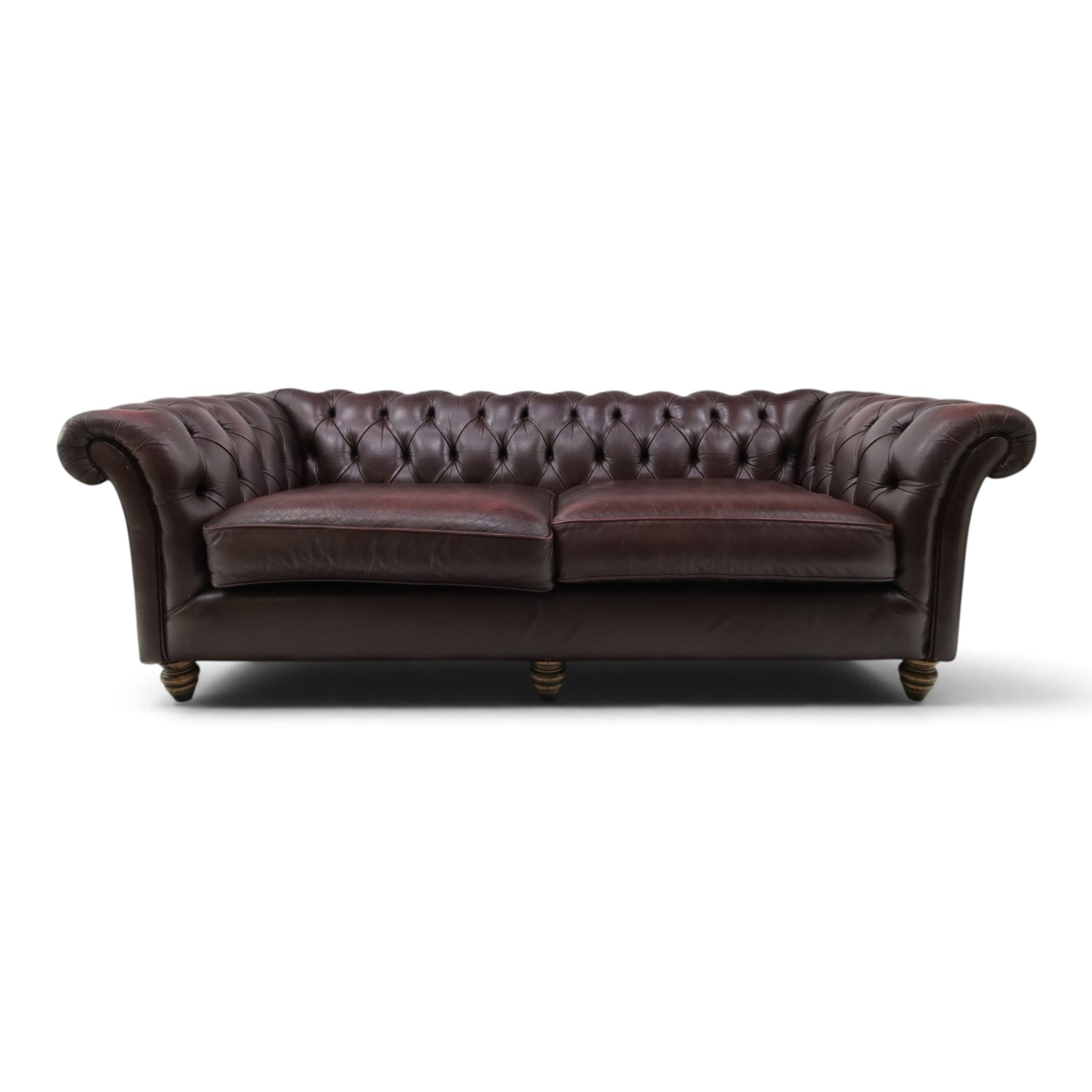 Thomas Lloyd - traditional shape Chesterfield two seater settee with rolled back and arms, upholstered in buttoned deep oxblood leather with loose seat cushions, raised on turned feet