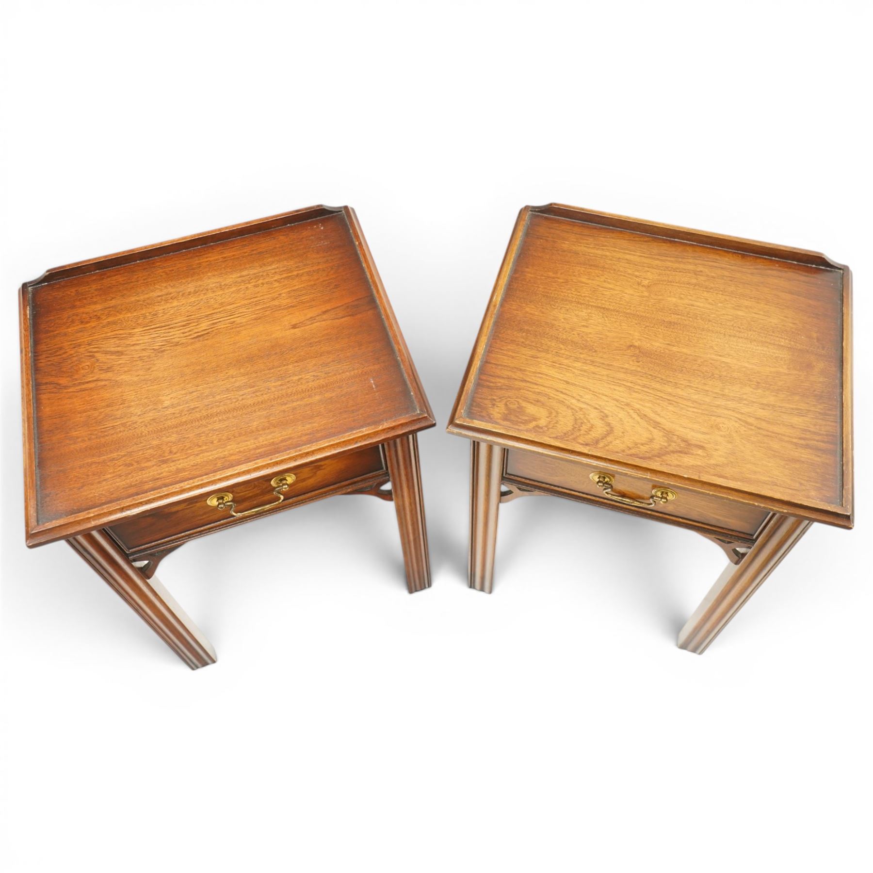 Pair of mahogany bedside tables, with quarter galleried top, single drawer with brass swan neck handle, pierced spandrels on fluted square supports  