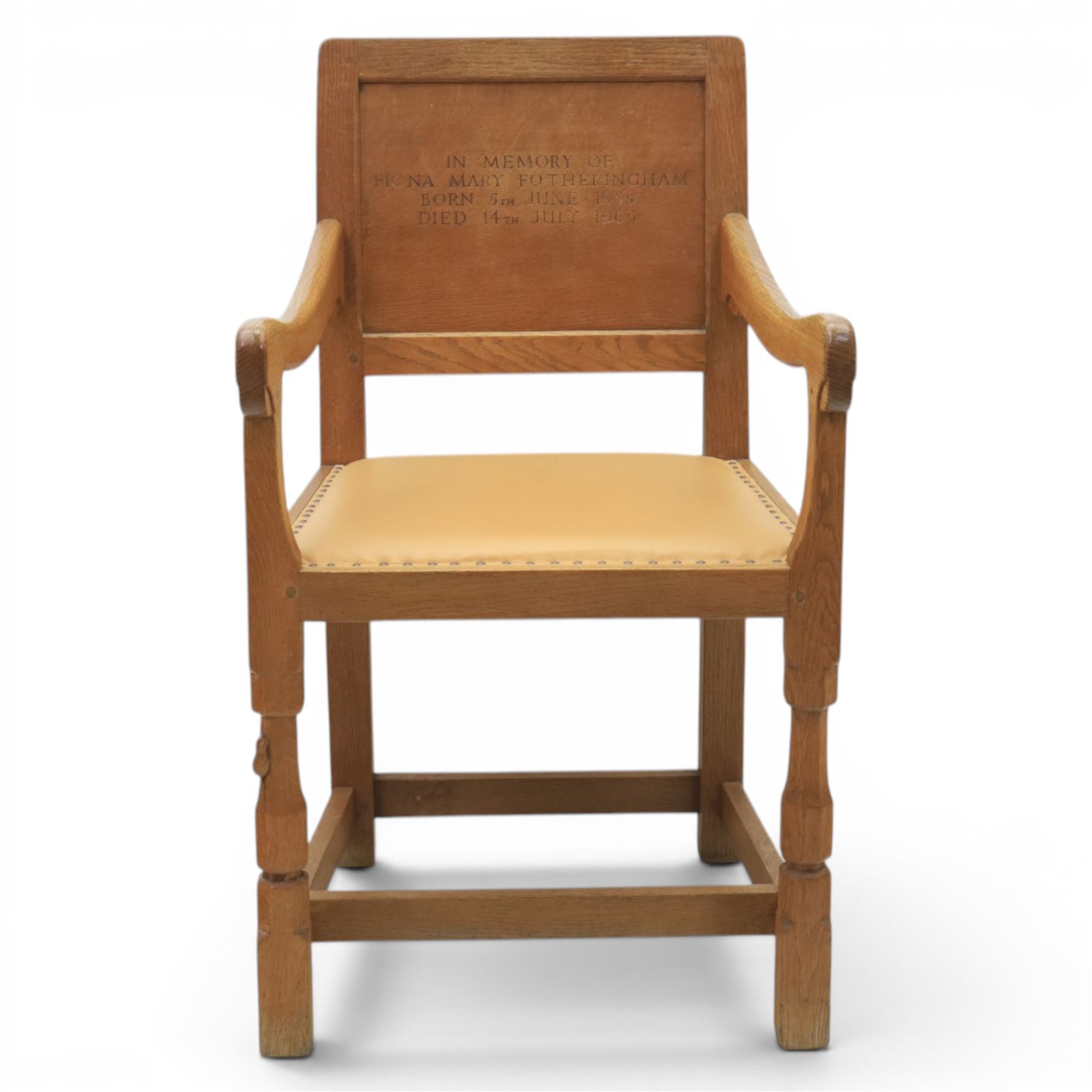 Mouseman - oak panel back carver armchair, with commemorative back panel engraved 'In memory of Fiona Mary Fotheringham Born 5th June 1958 Died 14th July 1965', above tan seat with brass studded trim, with carved Mouse signature, by Robert Thompson's of Kilburn