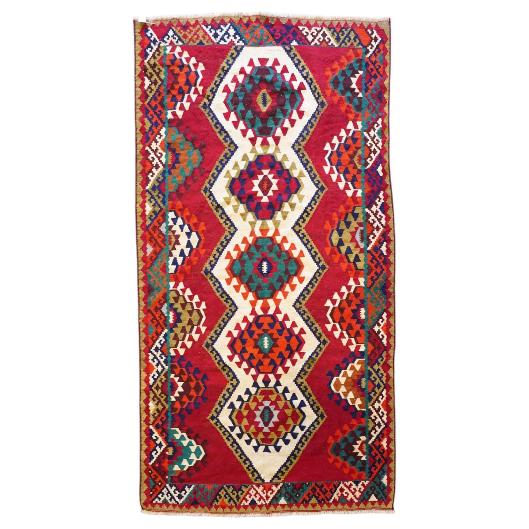 Persian Qashqai crimson ground rug, the central narrow ivory field decorated with repeating hooked geometric lozenges in multicolours, with a densely decorated guard band