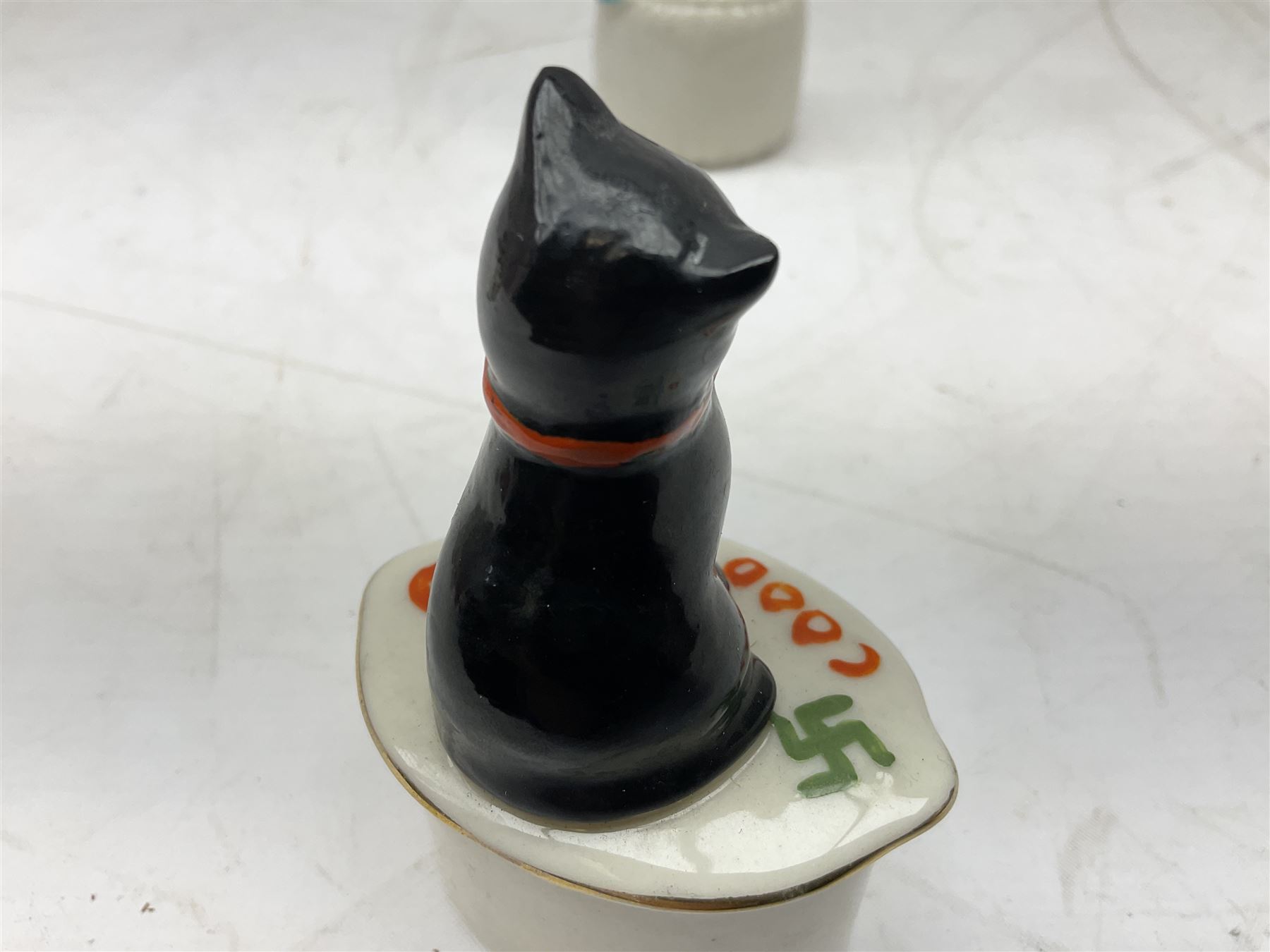 Five crested ware Good Luck black cats, comprising two Willow Art examples, two Arcadian examples and one Carlton China, to include Bridlington, Hull, Filey, etc, tallest H9cm