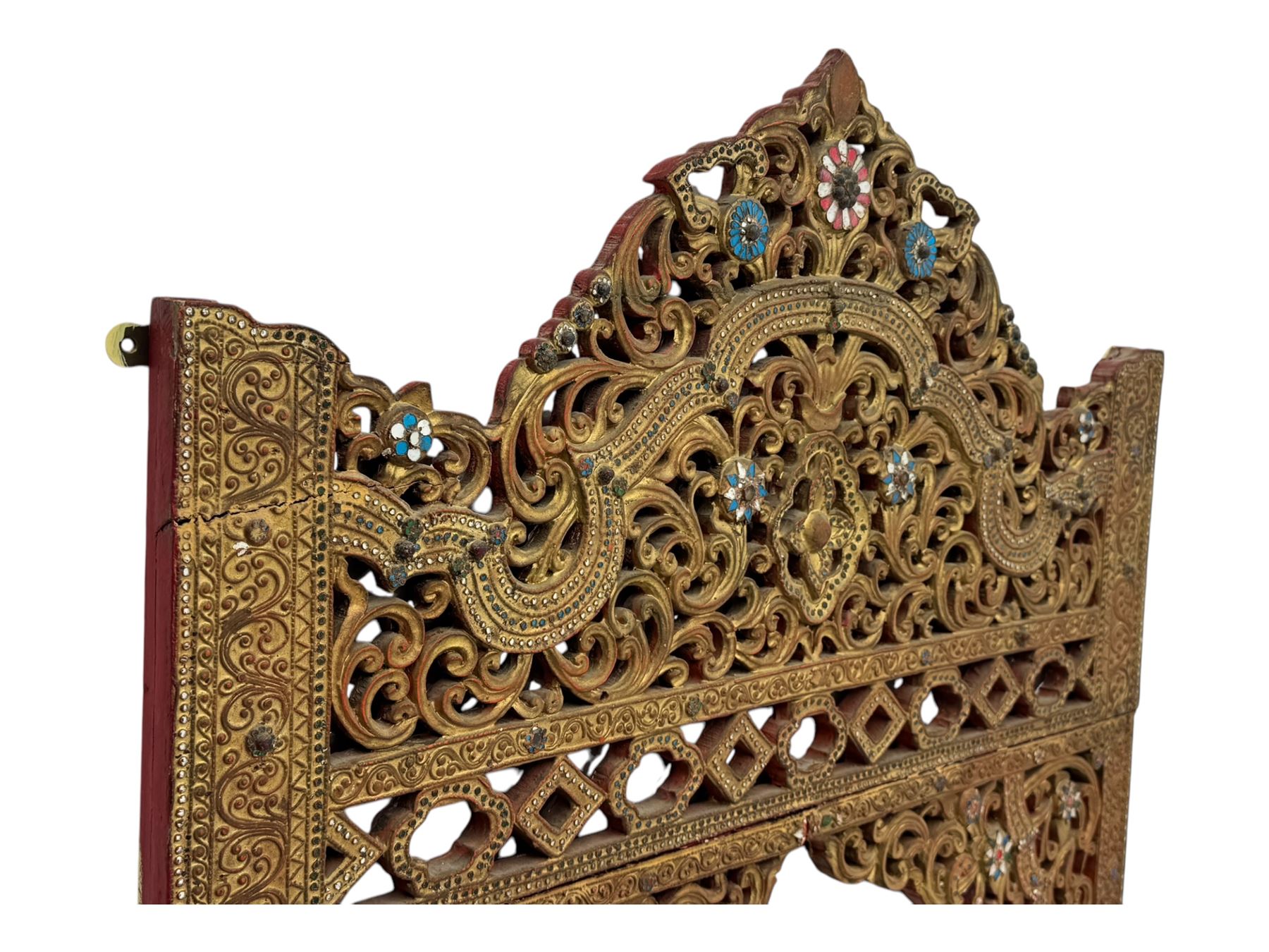 Large North African design carved and painted wall mirror, decorated with floral motifs, pierced foliate scrolls, inset mirrored panels, and colourful painted detailing, enclosing an oval bevelled mirror plate