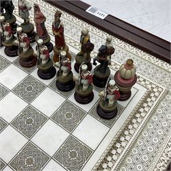 Franklin Mint Indian ' The Raj ' chess set with marble effect chess board within a mahogany stained frame raised on a brass mounted pedestal base with single fitted drawer, the playing pieces depicting figures from the 1857 Raj mutiny 52cm square H68cm