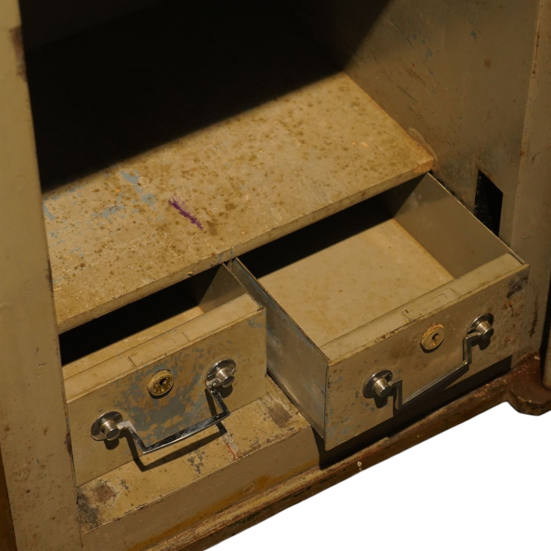 Early 20th century painted iron and steel safe, square form with moulded panel door, applied handle and lock plate with three keys, the interior fitted with twin cash drawers with recessed handles, on low cast feet