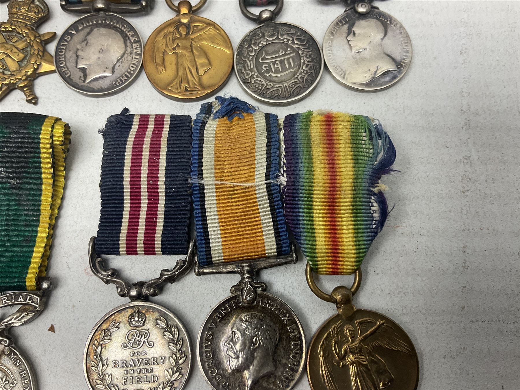 George V Military Medal and Distinguished Conduct Medal miniature group of seven medals comprising MM, DCM, WW1 trio including 1914 Star with date clasp and MID leaves, The Great Durbar Delhi 1911 Medal and LSGC; on pinned wearing bar; WW1 Military Medal miniature group of three comprising MM, BWM and Victory; Victoria North West Canada 1885 miniature; and George VI miniature Territorial Efficiency medal; all with ribbons