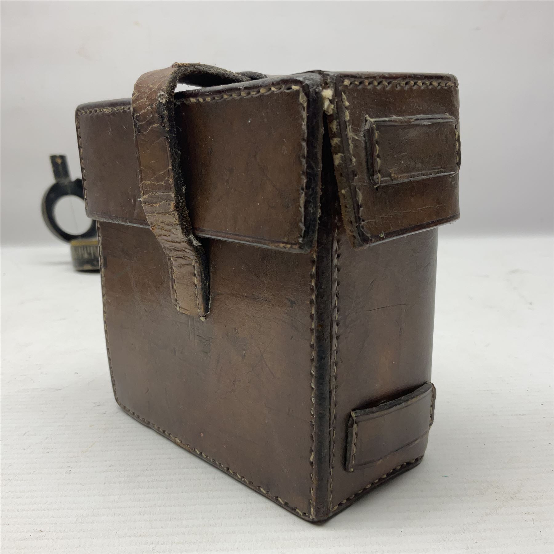 WWII British marching compass, the black lacquered brass case inscribed T.G.Co.Ltd. No.B100228 (broad arrow) 1941 Mk.III; and a ship's brass cased clinometer, the silvered dial marked R(arrow)L, D9cm; in leather carrying case (2)