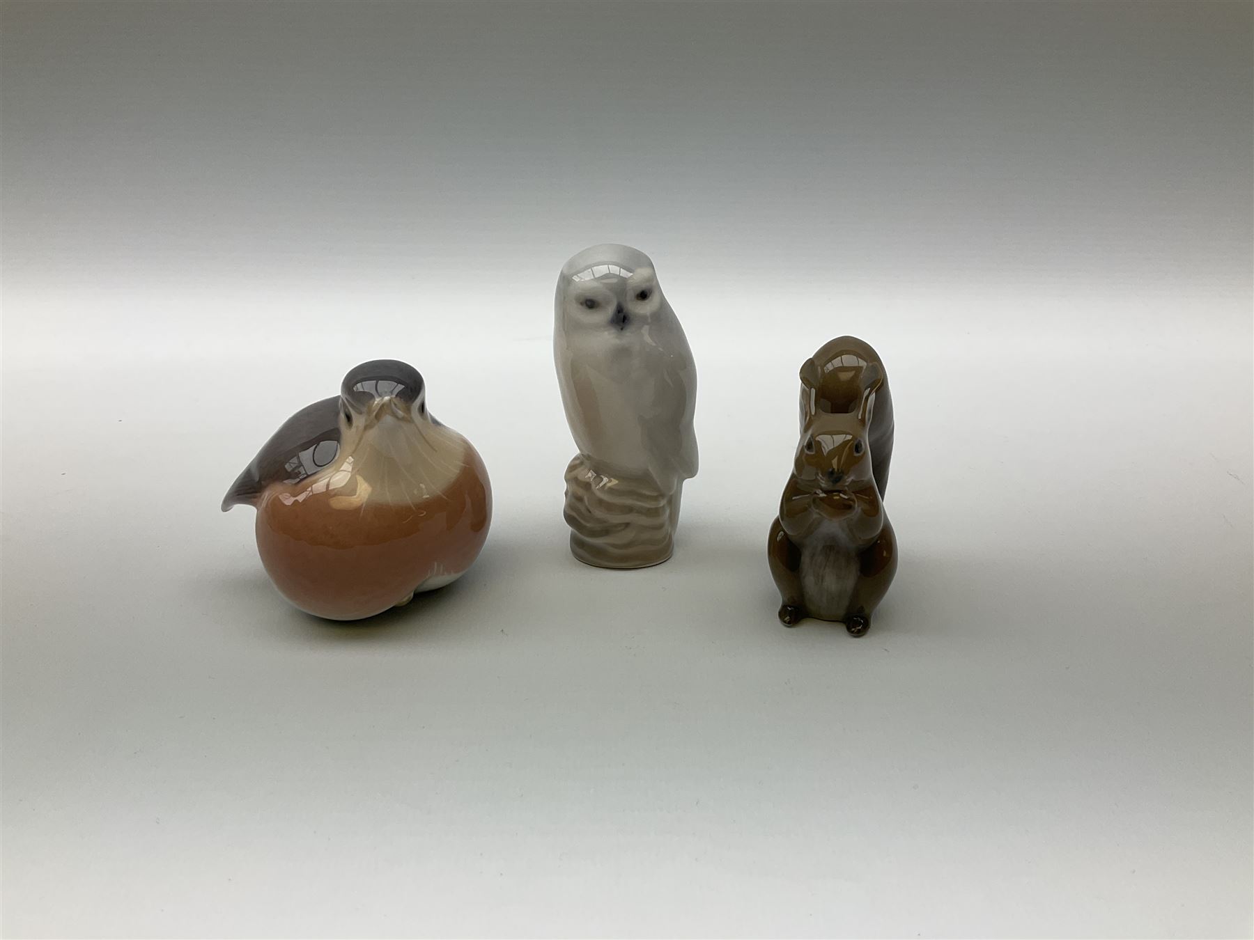 Eight Royal Copenhagen figures, cockerel 1025, hen 1024, group of two geese 609, robin 2266, squirrel 982, cockerel 1127, goose 1088 and owl 1741.  