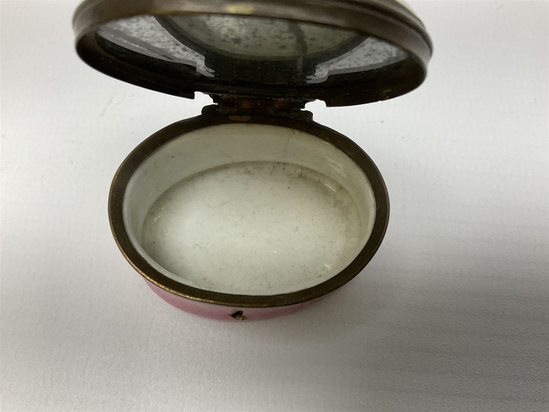 Late 18th century Staffordshire enamel patch box, of oval form with pink base, the hinged cover inscribed 'Have Communion with few, Be familiar with One, Deal justly with All, Speak evil of none' upon a white ground, opening to reveal mirror beneath, W4cm