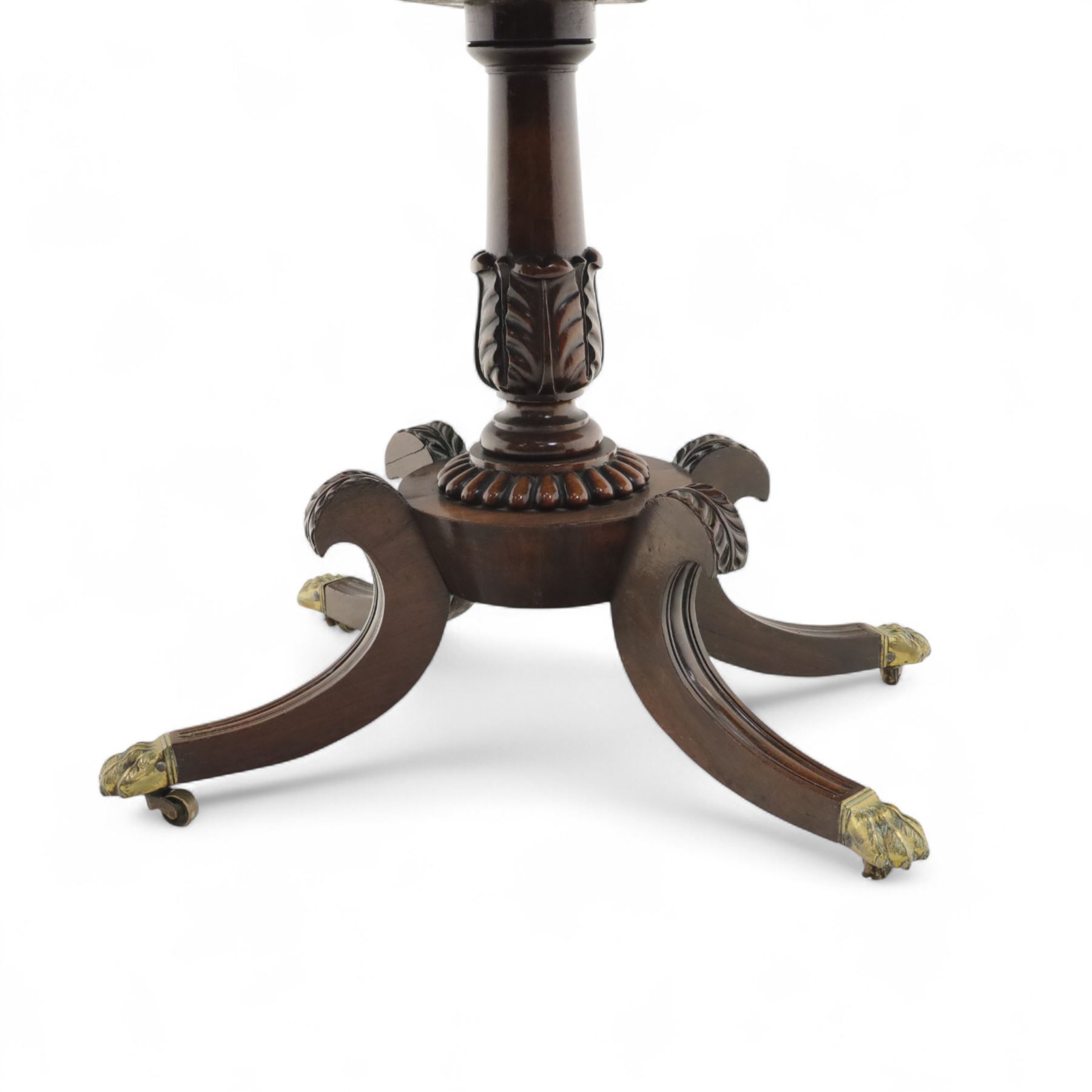 Regency rosewood fold over card table, the rectangular top with rounded corners and gadrooned edge opening to reveal a green baize lined interior, raised upon convex lobbed and acanthus pedestal and four fluted sabre legs, terminating in brass lion paw feet and castors