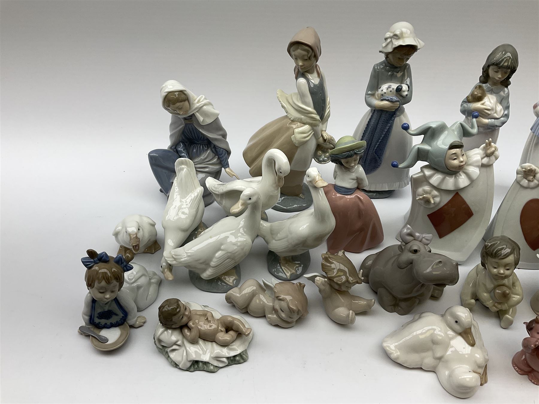 Collection of Nao figures, including four playing card jesters, two clowns, Virgin Mary and baby Jesus , five geese etc. 