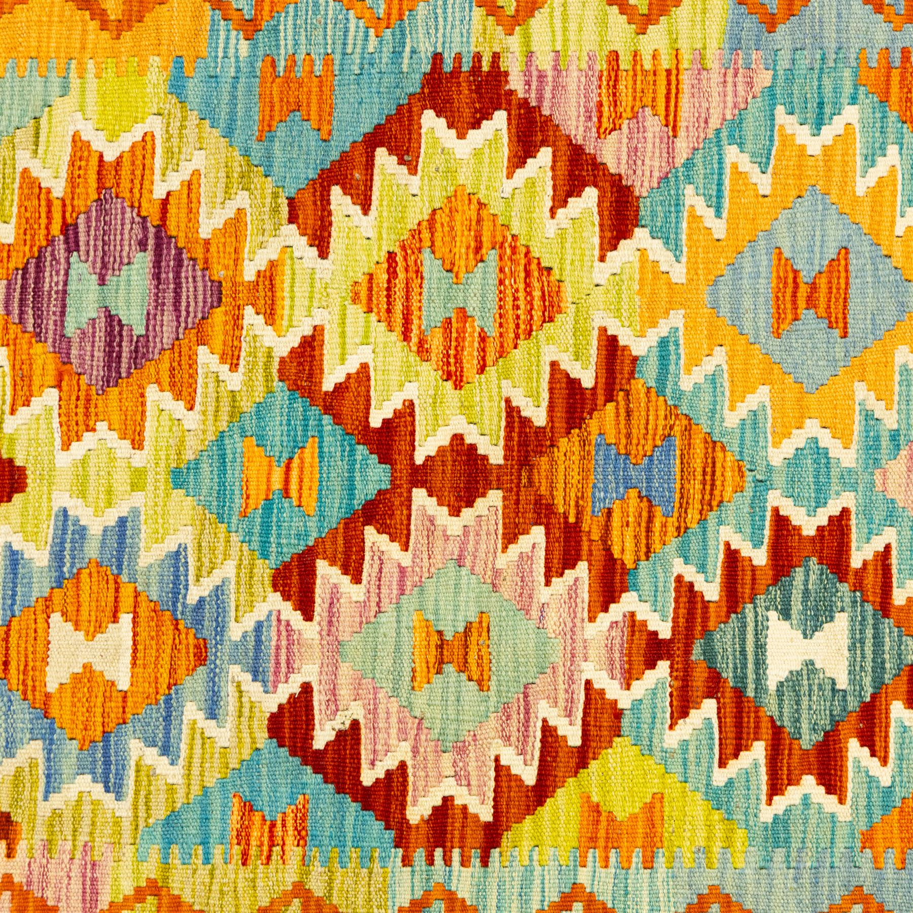 Afghan Chobi kilim flatweave runner with a repeating stepped diamond medallion design in live green, rust, teal, purple, and ivory, framed by chevron and geometric borders