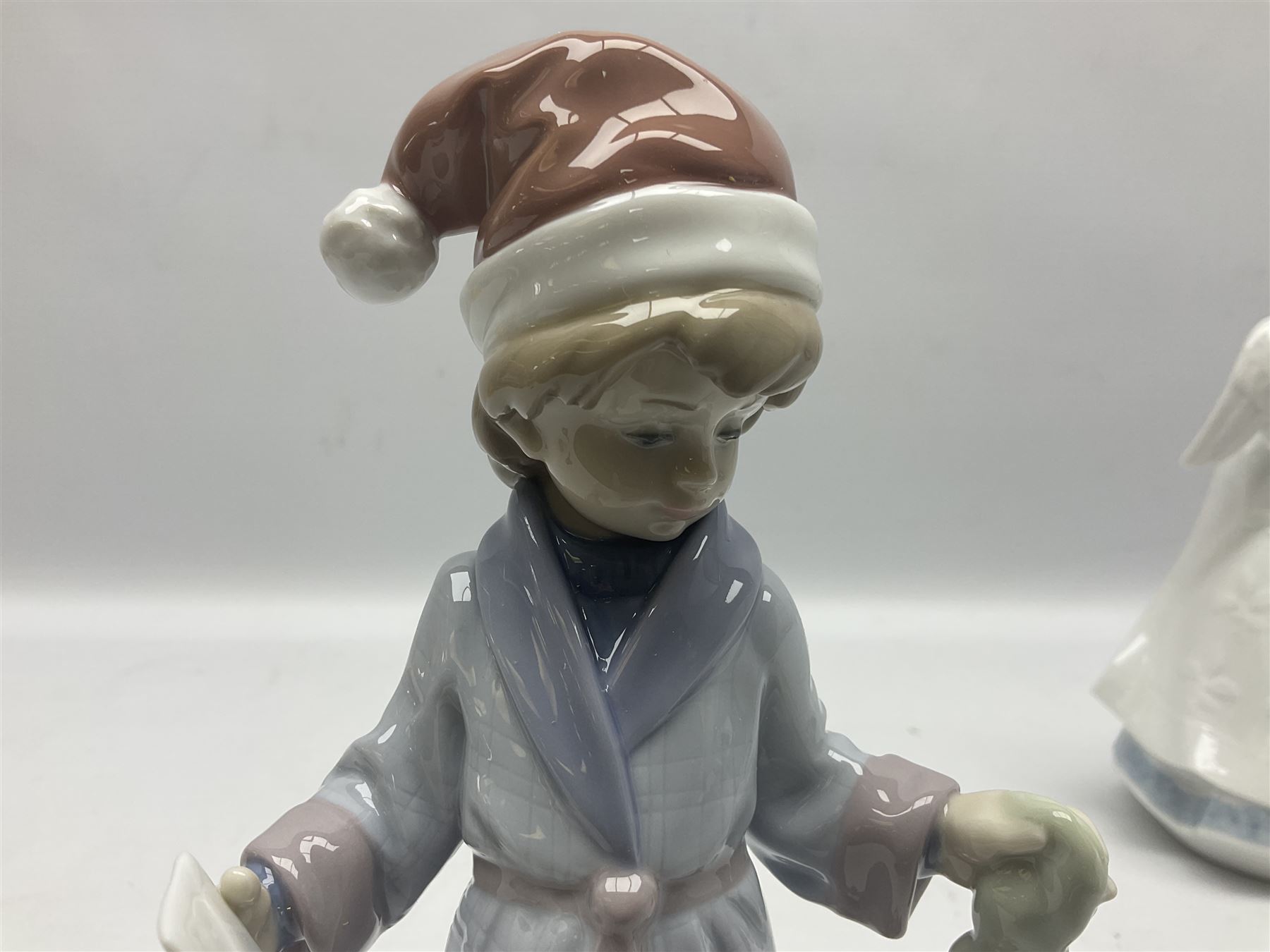 Three Lladro figures, comprising Dear Santa no 6166, Angelic Melody 1993 no 5963 and Seraphs Head no2 no 4885, together with Lladro plaque Love Brings Us Together no 7677, all with original boxes, largest example H18cm