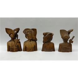 Two pairs of Balinese carved wooden bust figures of a man and woman, with elaborate head dresses, along with other wooden carved figures, a small barometer and a framed print. 