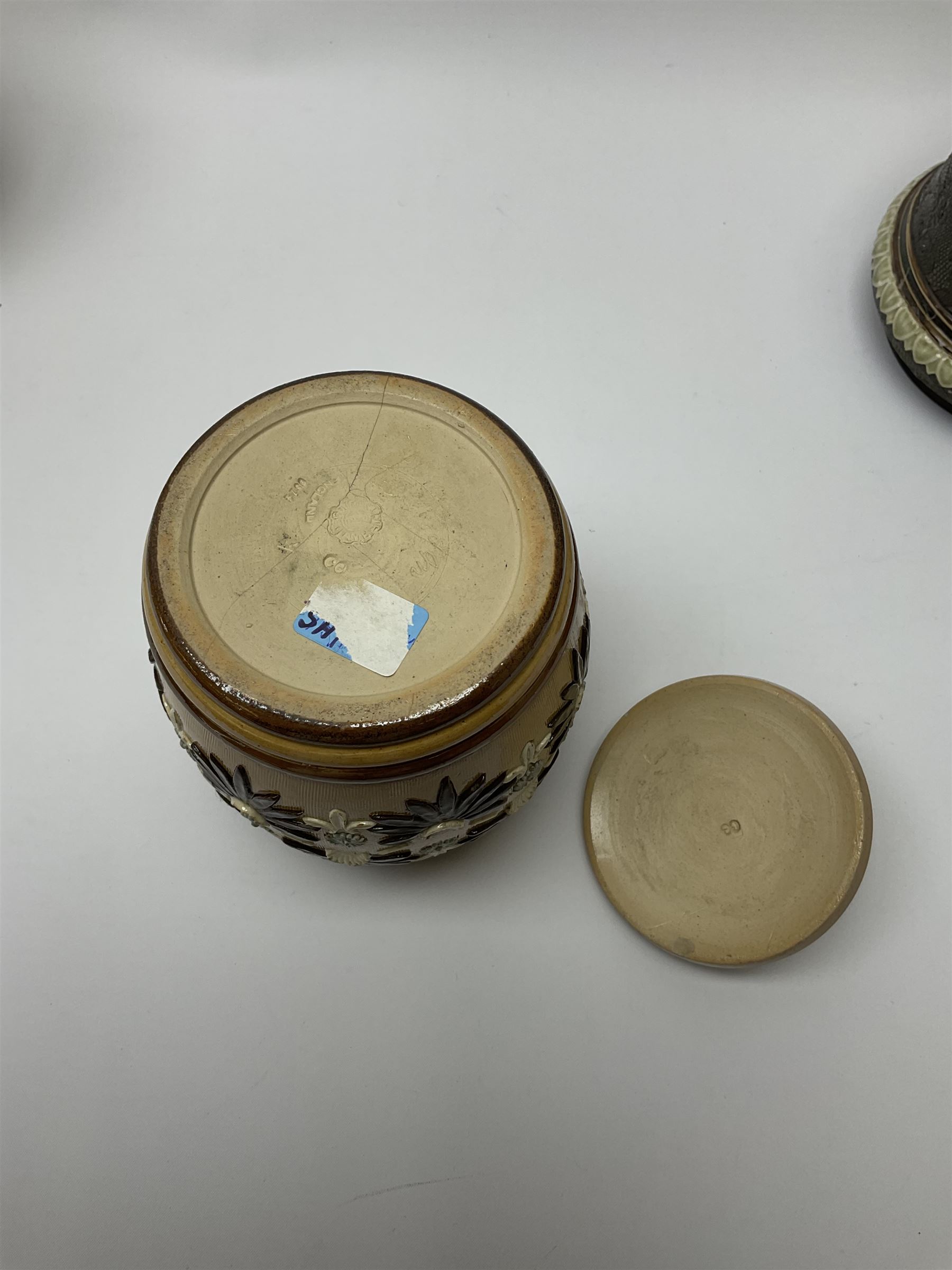 A group of Doulton Lambeth and Royal Doulton tobacco jars, to include examples with relief moulded foliate decoration, each with impressed marks and markers monograms beneath. 