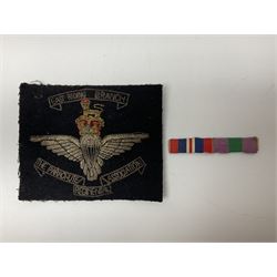 Parachute regiment - chrome crest on oak easel shield; three cloth badges; small silver plated figure; and pin badge; together with 10cm diameter cannon ball etc