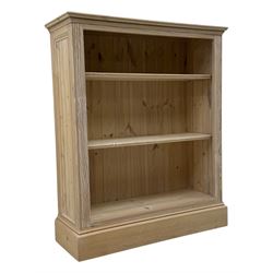 Contemporary light pine open bookcase, rectangular top with stepped moulded edge above a boarded back, fitted with two adjustable shelves, on a plinth base