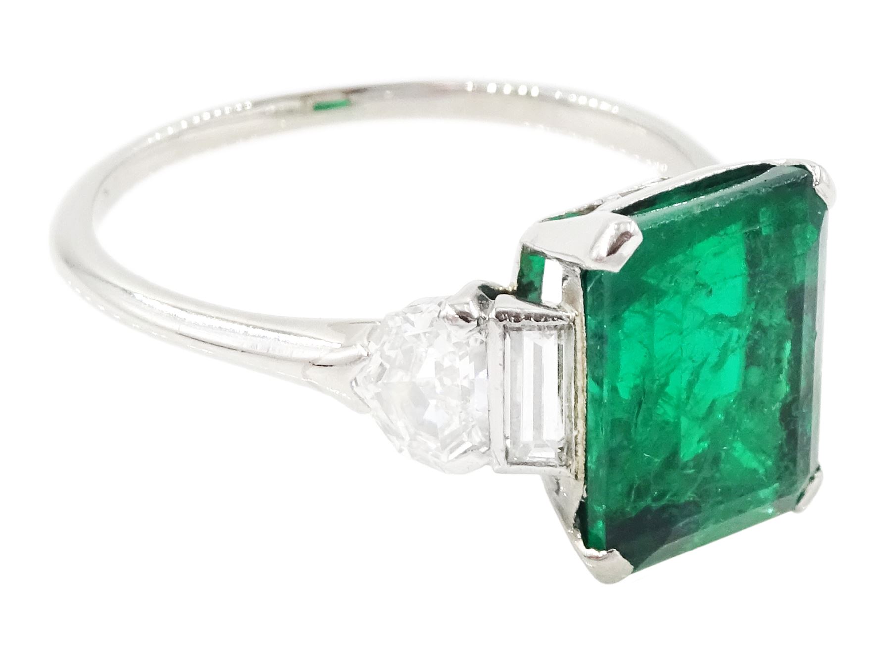 Platinum Colombian emerald and diamond ring, single emerald cut emerald of approx 3.00 carat, each side set with a single baguette cut and heptagonal cut diamond, with The Gem & Pearl Laboratory report
