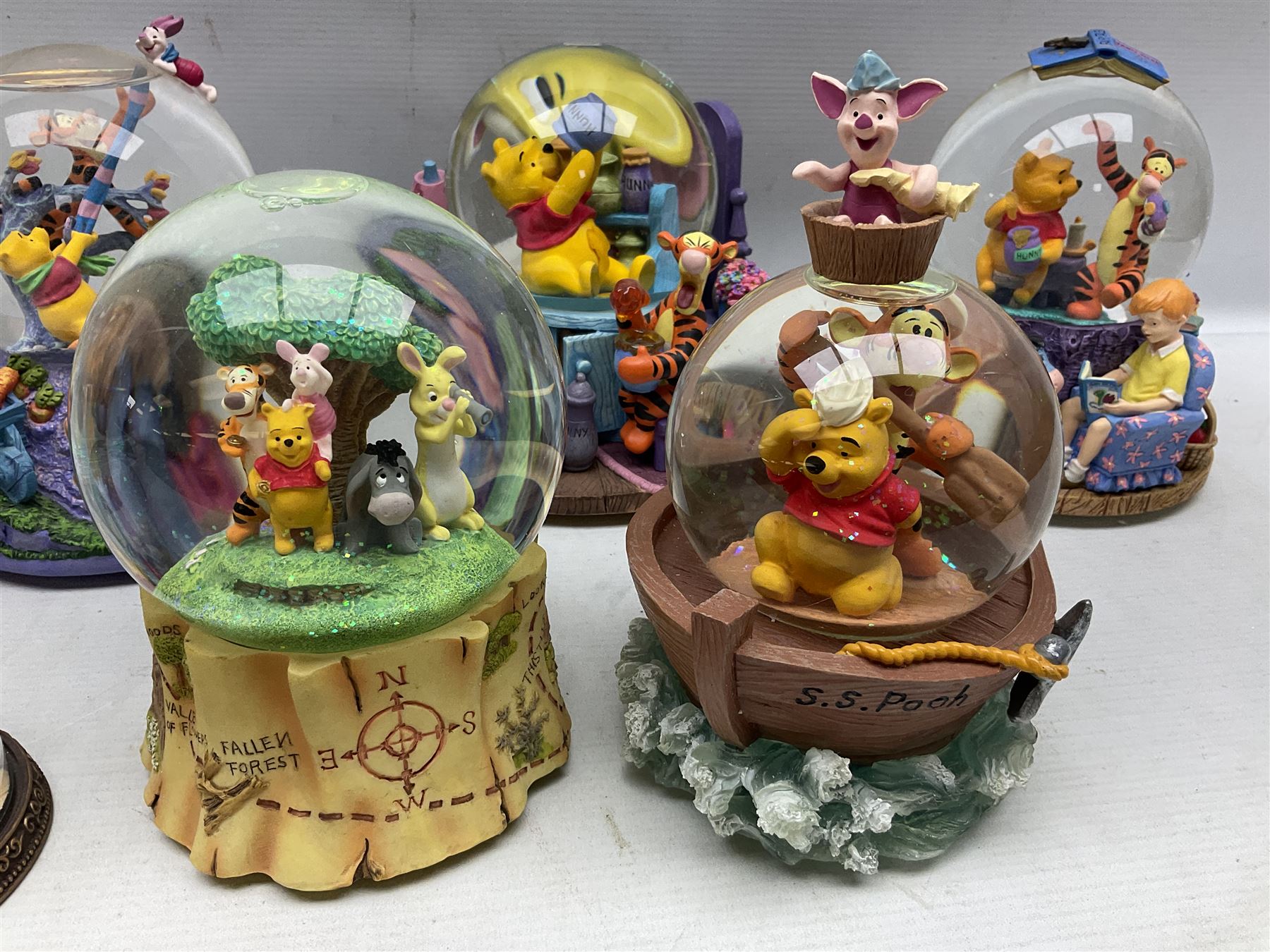 Five Disney Winnie The Pooh snow globes, to include Pooh and Piglet Sailing, Pooh's Grand Adventure and Blustery Day, together with The Walt Disney Classic Waterglobe collection globe and group Tigger, Winnie and Piglet figure under dome, all with boxes (7)