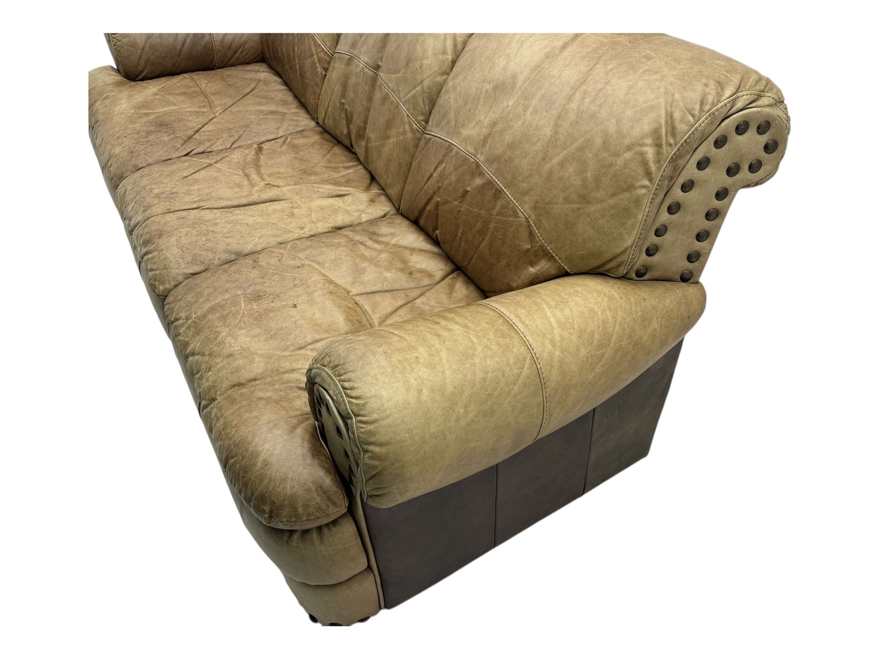 Contemporary three-seat sofa, upholstered in stitched brown leather with brass studwork decoration, rolled back and arms, raised on turned supports