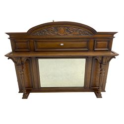 Oak overmantle mirror, arched pediment carved with shield and flanking fish with trailing scrollwork, panelled frieze over extending canopy raised by turned and fluted column pilasters, bevelled mirror plate 