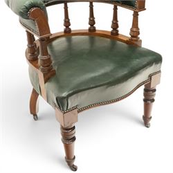 Late Victorian mahogany framed Captains tub desk chair, the green leather upholstered cresting rail over turned spindle supports over a sprung seat, raised on front turned supports terminating to ceramic castors