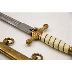 WWII period German Kriegsmarine navel officers dress dagger by Carl Eickhorn, Solingen, with gilded pommel and cross guard with press stud release button, white celluloid grip with wire binding, housed in its original brass scabbard with two hanging rings, the etched double edged blade with Carl Eickhorn, Solingen makers trademark to the base, L39cm