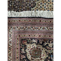 Large Fine Persian Tabriz carpet, dark blue field profusely decorated with small Herati motifs and large cusped pole medallion with matching spandrels, multiple guarded border, the main band decorated with trailing foliage design and stylised leaf and flower head motifs