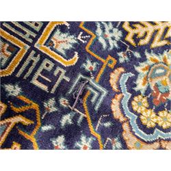 Persian indigo and pale gold ground rug, overall busy geometric design, the field decorated with hooked Hac and palmette medallions surrounded by densely patterned zig-zags and stylised foliate motifs, the border decorated with smaller Hac motifs, within multiple guard stripes 