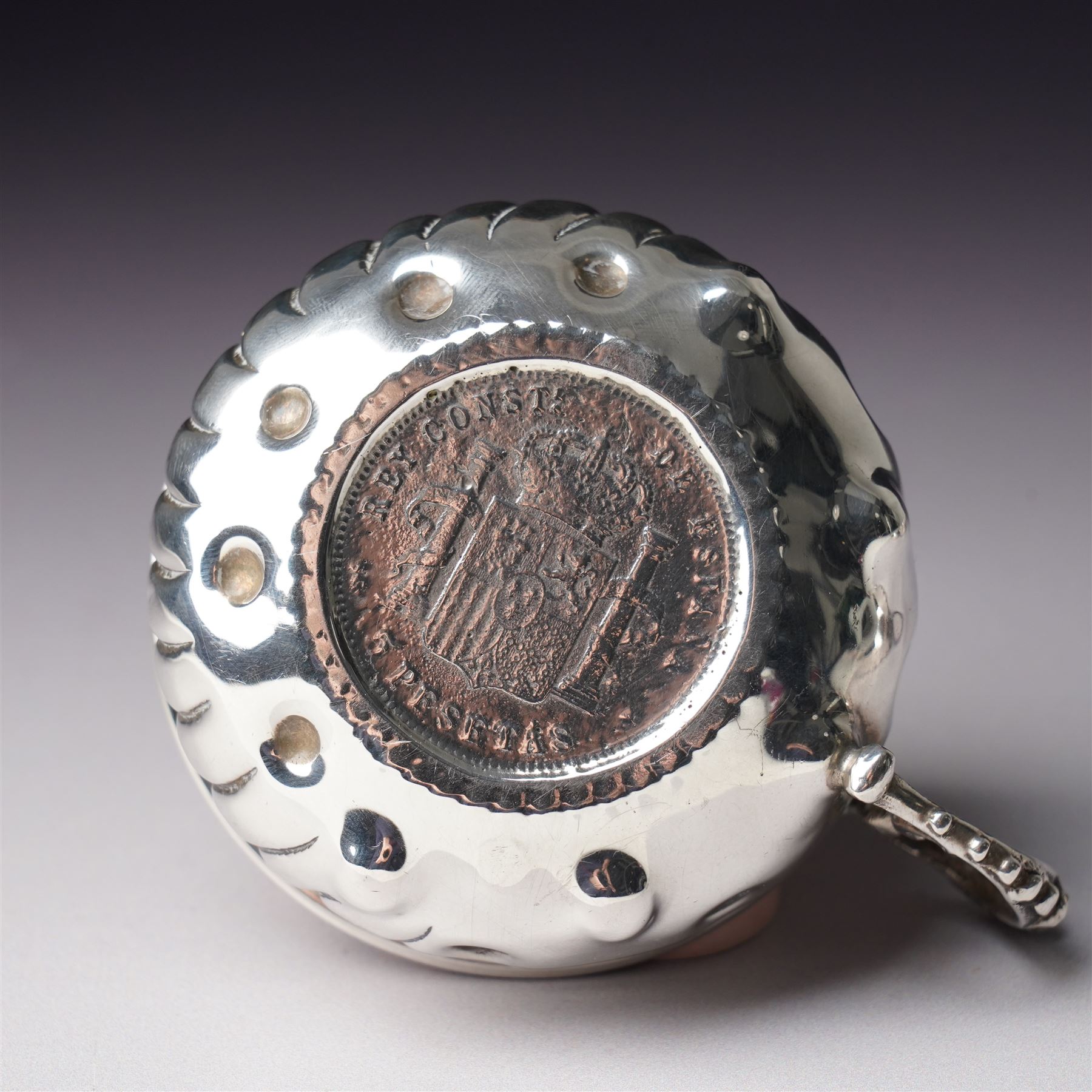 French silver tasse de vin with Minerva's head and makers mark J.P. with an anchor, the rim engraved C Mouly, Spanish tasse de vin inset with a silver coin and two other tasse de vin (4)