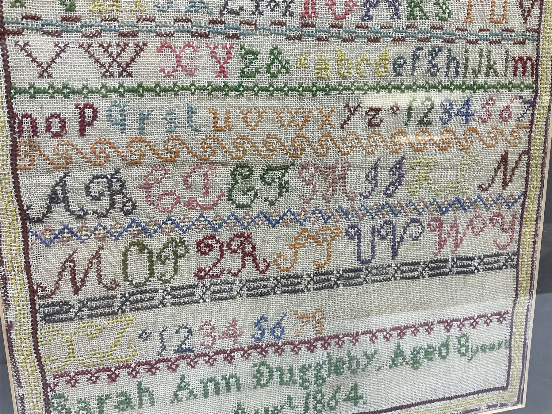 Victorian sampler, worked by Sarah Ann Duggleby, dated August 1864, depicting lines of alphabet, framed and glazed, by vendor repute Beswick Hall provenance, overall H46cm L43cm