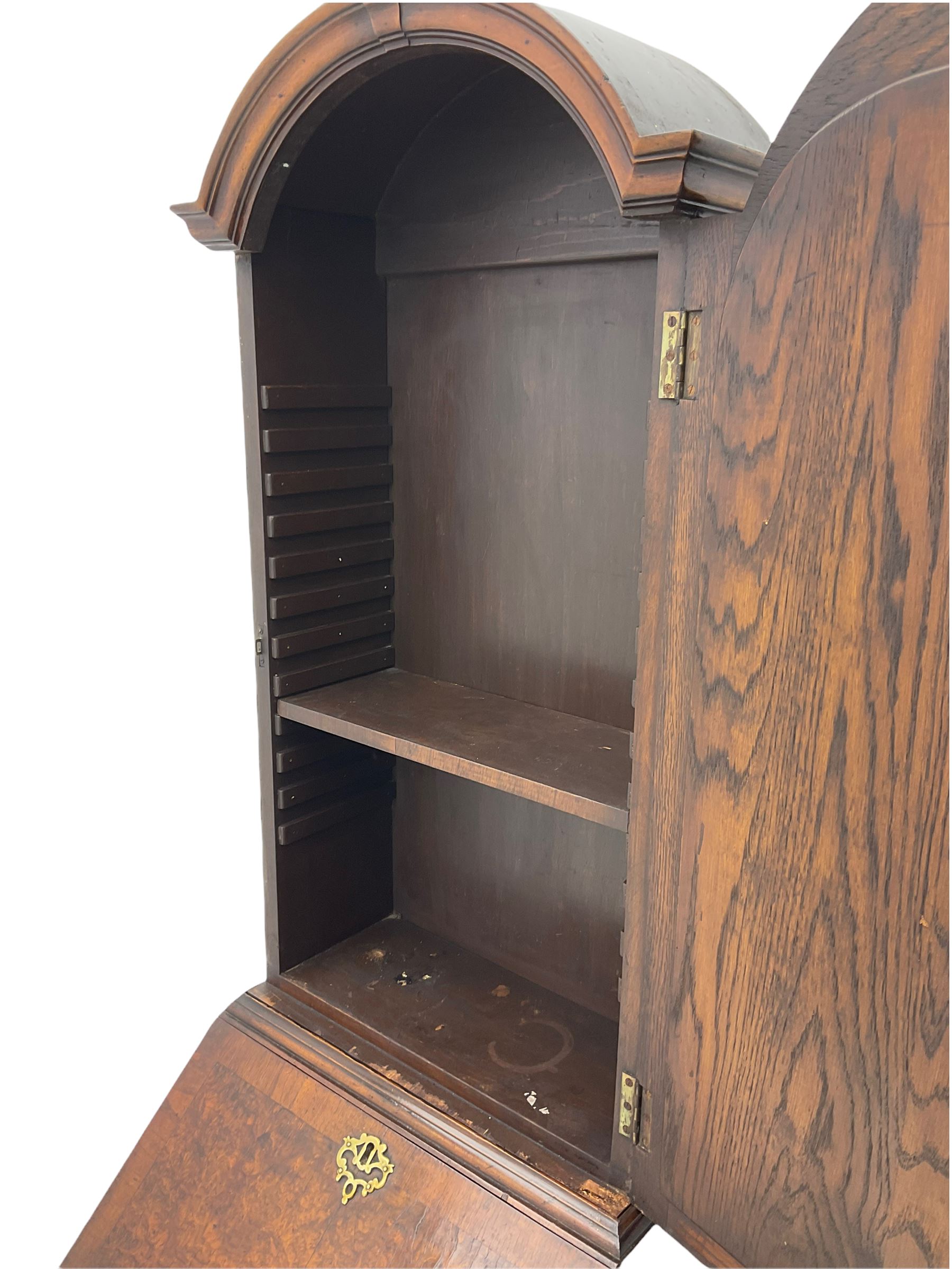 Small early 20th century Queen Anne style bookcase on bureau secretaire, the moulded arched pediment over mirrored door in shaped frame, the bureau fitted with fall front enclosing curved fitted interior, cushion moulded drawer over single drawer, on scroll and shell carved cabriole supports