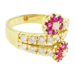 18ct gold ruby and diamond flower head crossover ring, two flowers each set with a single round brilliant cut diamond and six rubies, to diamond set stems and spaced by a row of nine diamonds, stamped 750, total diamond weight approx 0.55 carat