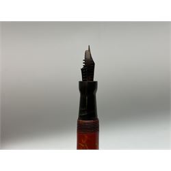 Vintage Swan Mabie Todd lever fill fountain pen in coral red, the nib a/f marked 14K, together with two further vintage Swan Mabie Todd fountain pens, the first example with lever fill, the other leverless, each with black body, one with nib marked 14ct, (3) 