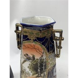 A pair of Japanese Nippon Kinjo vases, of tapering hexagonal form with twin stylised handles, the cobalt blue ground with oval hand painted panels to front and verso depicting landscapes, further detailed with smaller floral bands and panels and heightened with gilt, each with mark beneath, H30.5cm.  