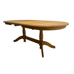 Pine extending dining table with additional leaf, on turned twin pedestals with splayed supports